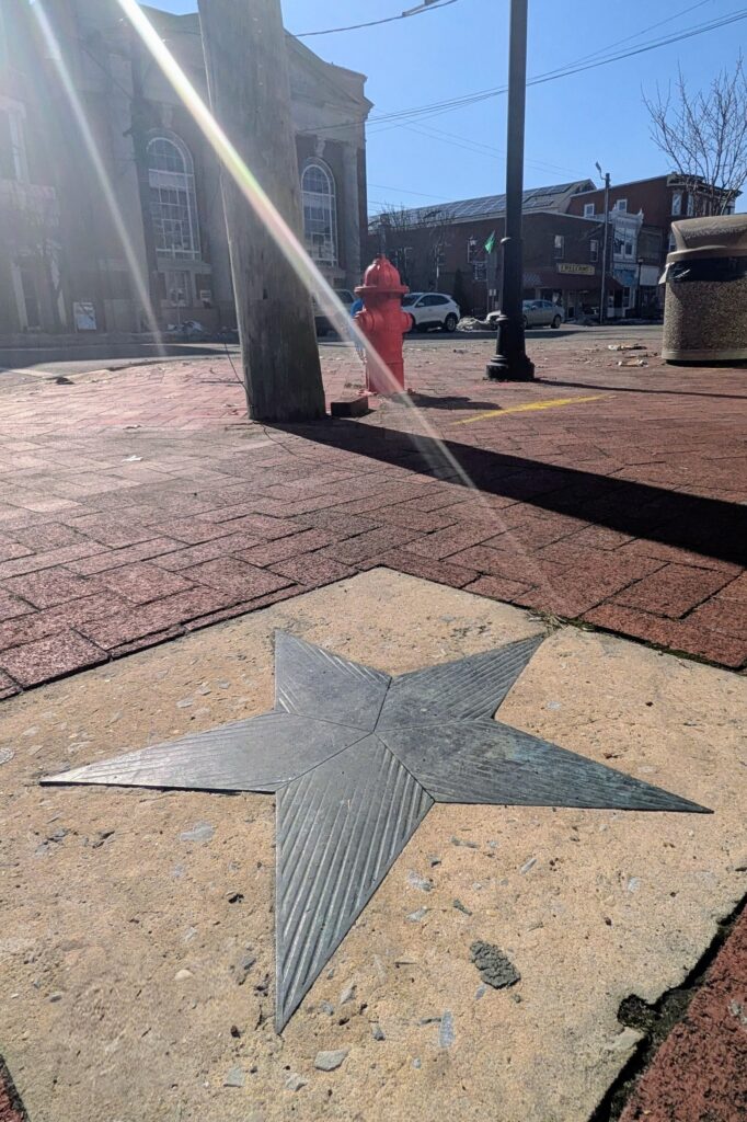 Ray of sun shines down onto the Salem star with West Broadway in the background in center of Salem City