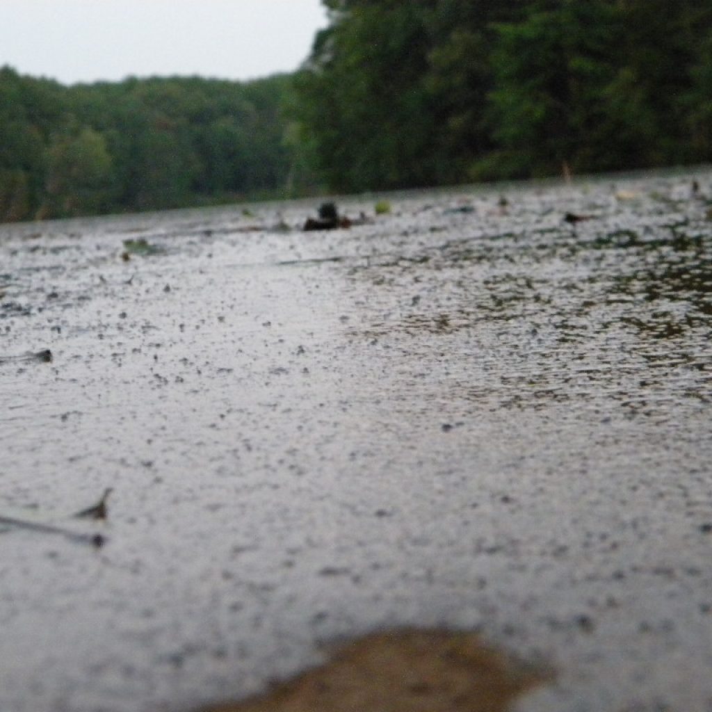 The gentle flowing water over the dam's surface.