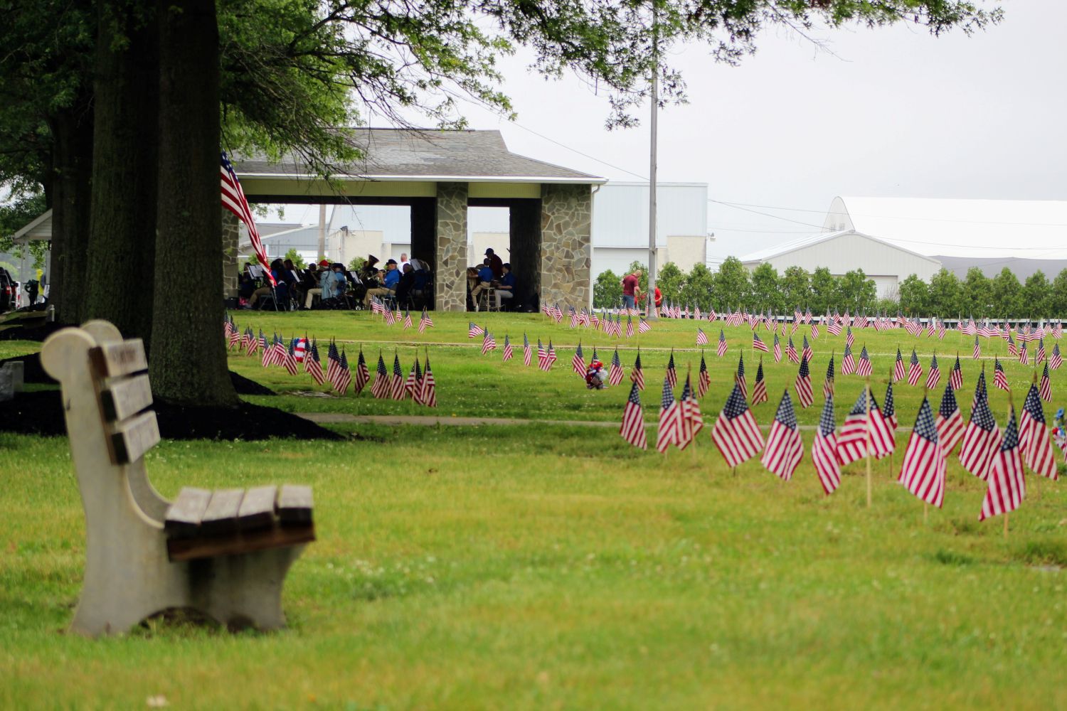 An empty bench overlooks the backhalf of the cemetery with the Salem American Legion Band in the background