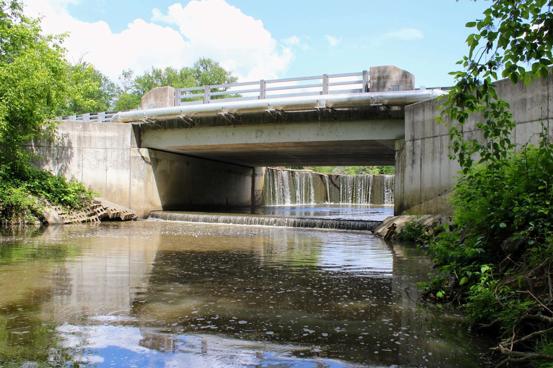 These images capture the concrete overpass bridge on East Lake Road and the beautifully tiered concrete cascade spillway hidden underneath, where water dramatically drops from the lake level.