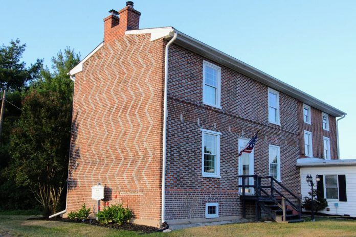 Chambless House in LAC Twp.2 The front facade of the Nathaniel Chambless House displaying the classic Flemish checkerboard pattern and a checkered stringcourse, transitioning into the bold zig-zag design of the south gable wall.