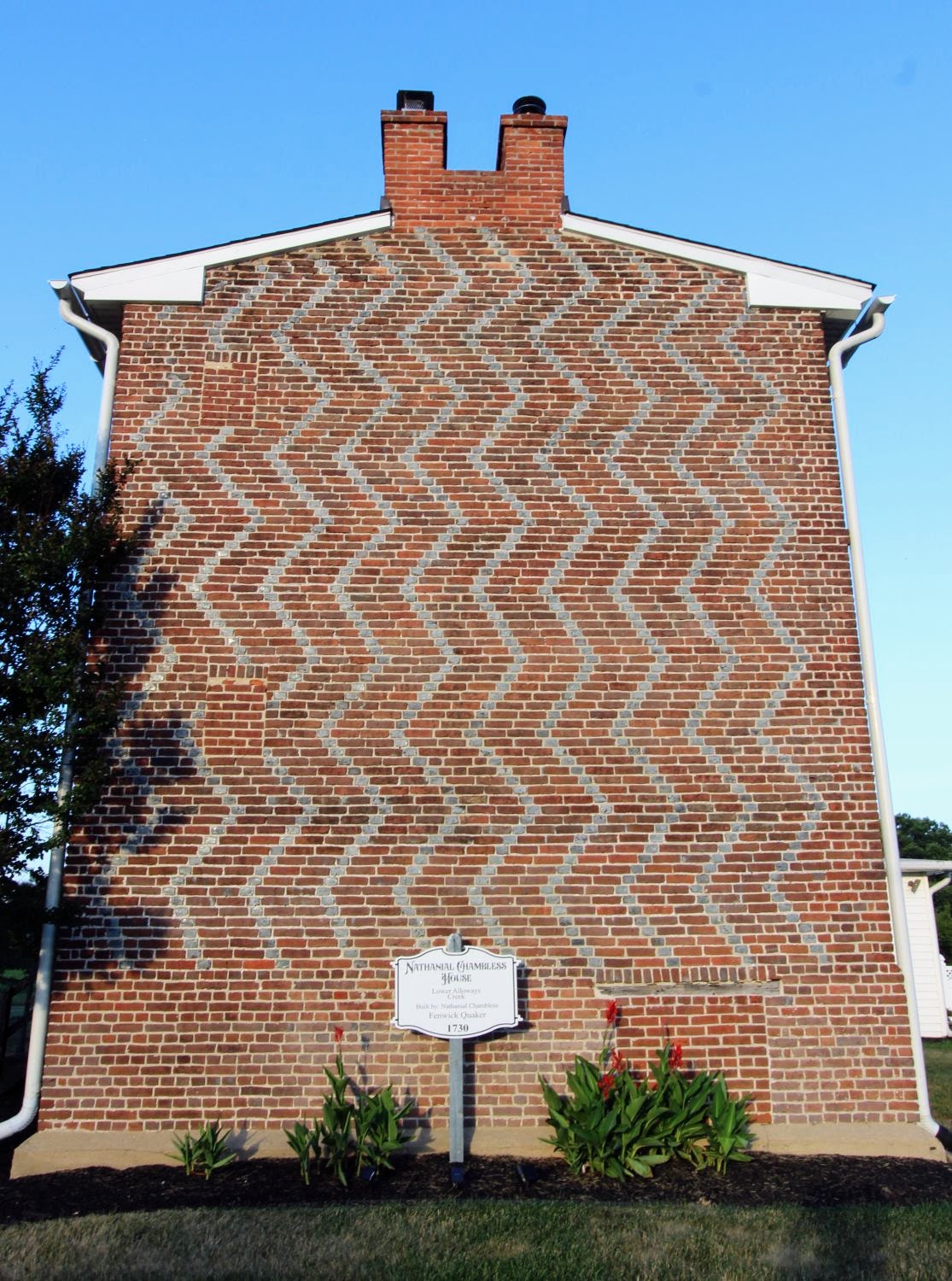 The historic marker standing proudly before the original, un-stuccoed 18th-century vertical zig-zag brickwork of the Chambless House.