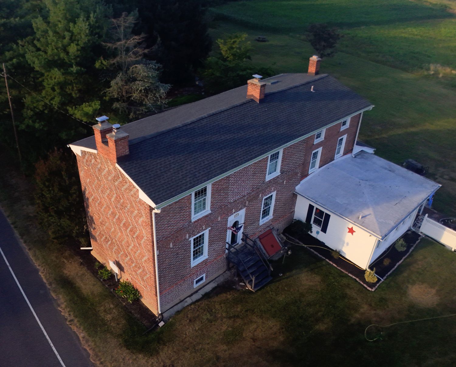 An aerial view from the west facing east, clearly illustrating the low roof pitch that architectural historians debate, as well as the modern repairs to the roofline.