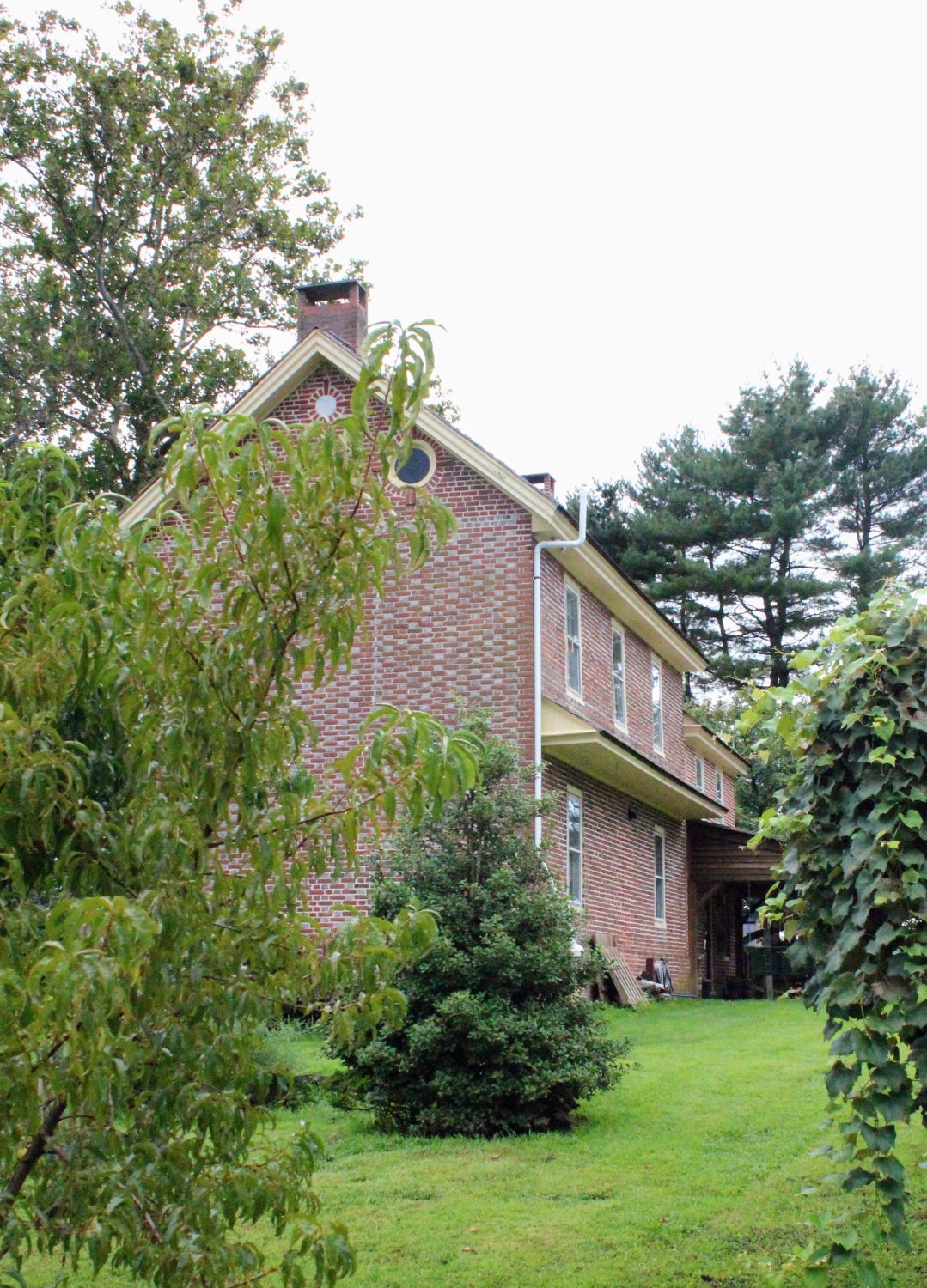 Distant side/gable view showing the full roofline and both eave windows in context