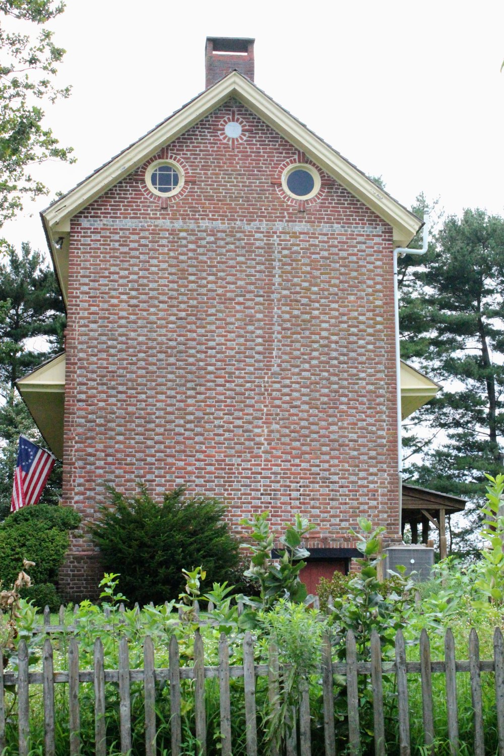 Eastern gable shot with the picket fence and garden in the foreground.