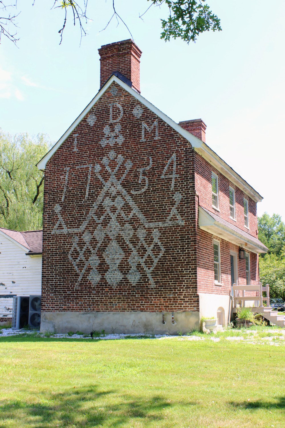 The west gable of the Dickinson House, built in 1754, still bears what Joseph S. Sickler called the most ornate glazed brickwork in America.