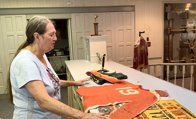 Karen Dingley inspects a jersey from the 1938 Penns Grove Eagles semi-pro football team that will be on display at the Historical Society of Penns Grove, Carneys Point & Oldmans starting next month.