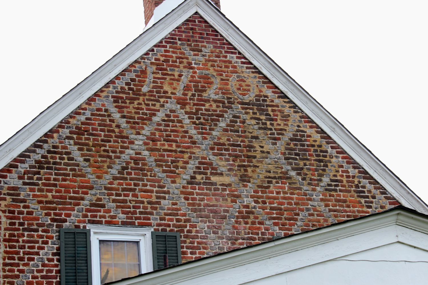 The date that rewrote Salem County's brick history: "1720" worked directly into the diaper-pattern brick on the Joseph Darkin House gable, discovered when a 1942 fire burned away the stucco that had hidden it for generations.