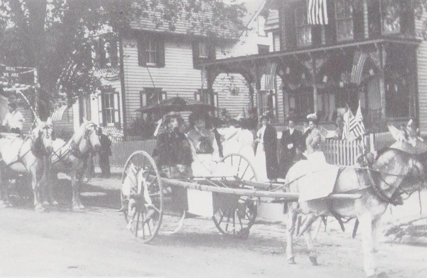 Donkey Float." A cart stands in the road and a woman holds a parasol, with a large porched house hung in flags and bunting behind them and a street sign at the corner. (How Dear to My Heart, p. 31)