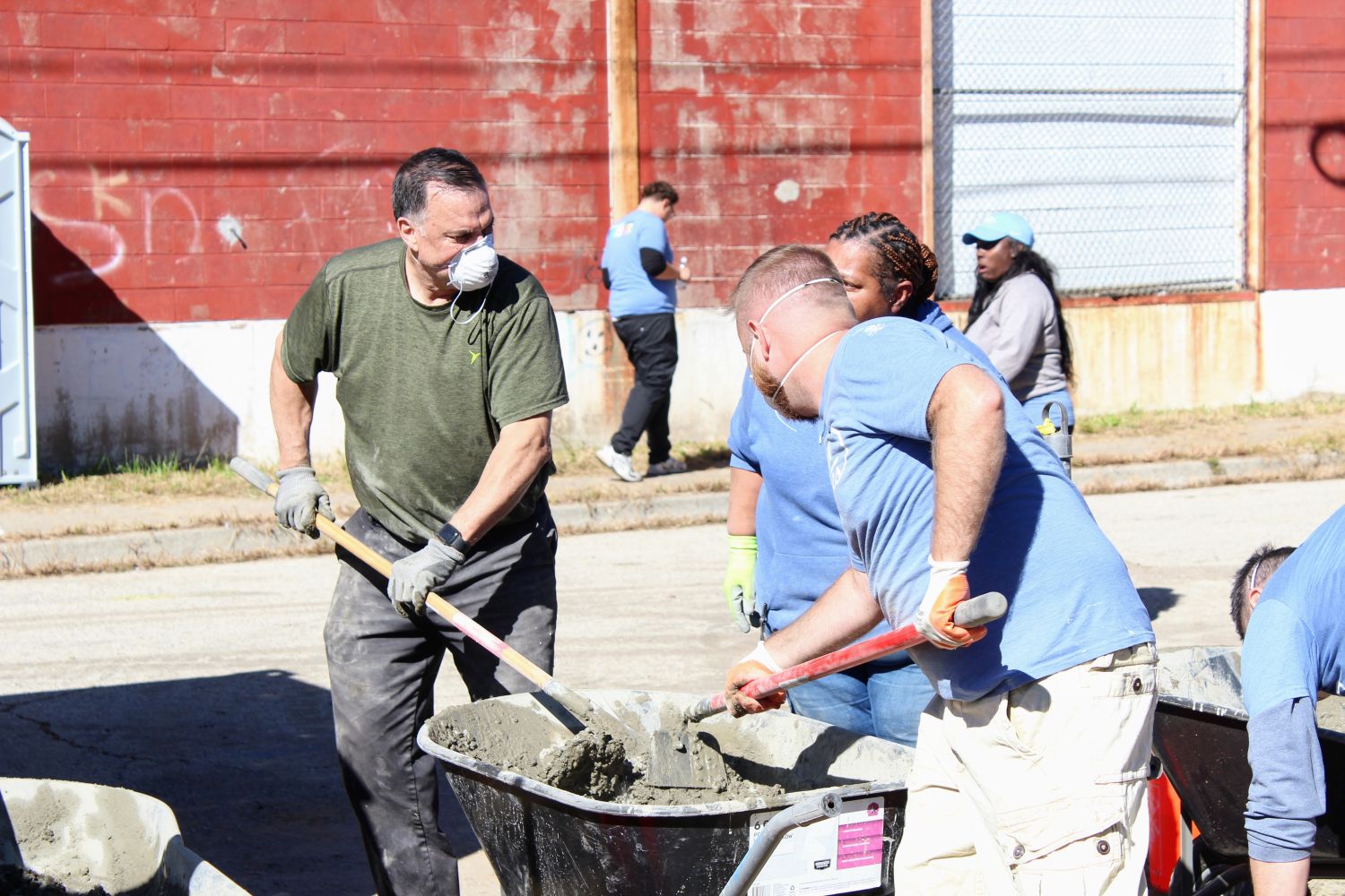 Two volunteers mixing concrete