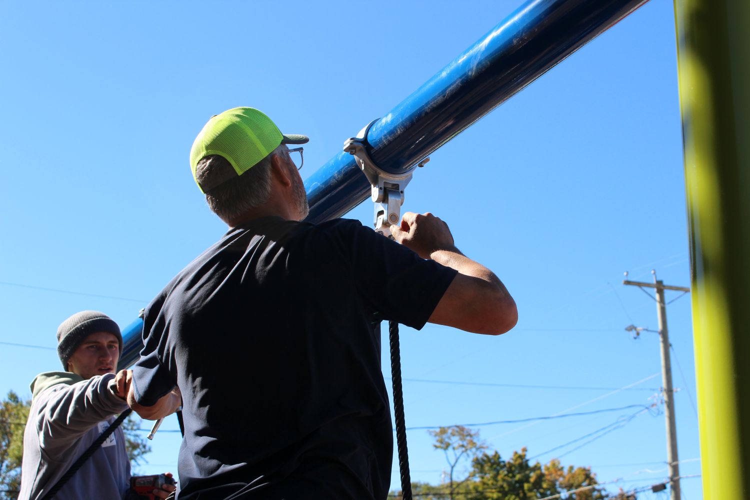 Worker hangs a swing at Hubbell Park