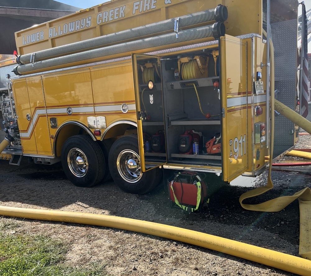 Lower Alloways Creek Fire & Rescue apparatus with supply lines stretched across the property.